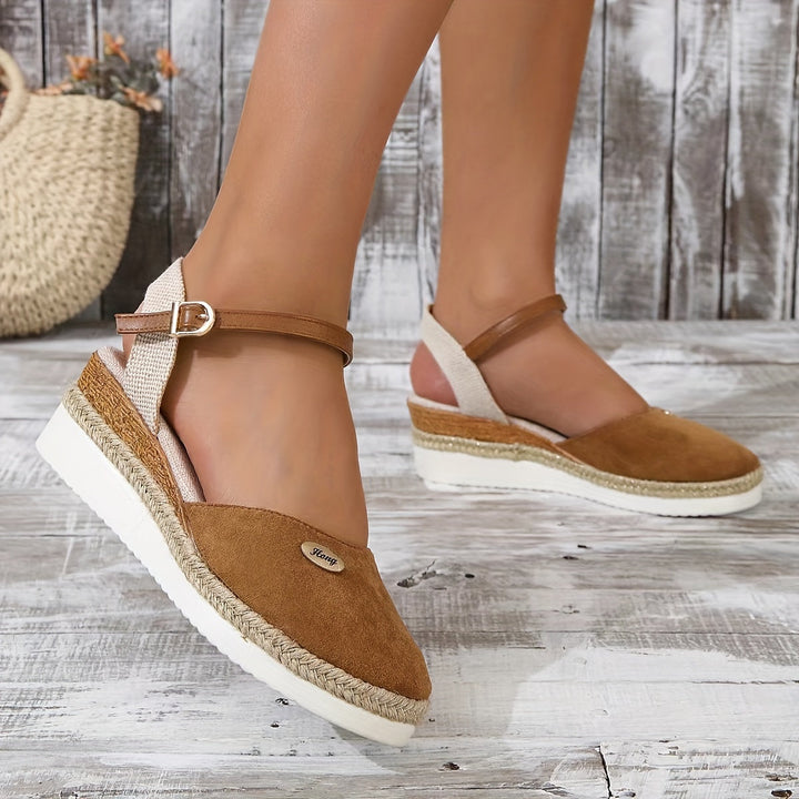 Close-up heel angle foot wearing sandals gray floor background