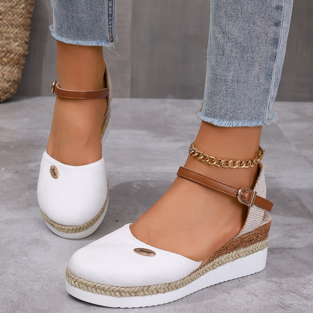 Foot model walking in wedge sandals on gray textured floor