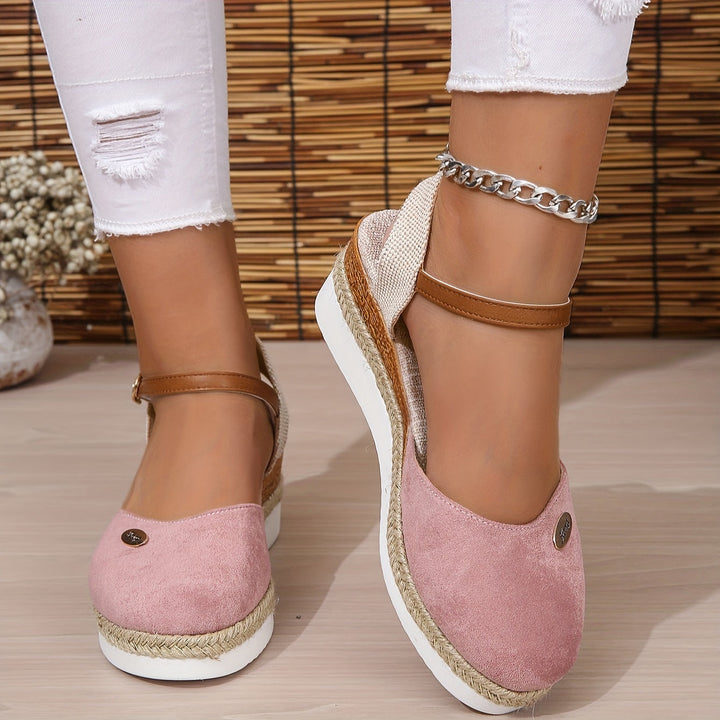Foot stepping forward in wedge sandals on gray background