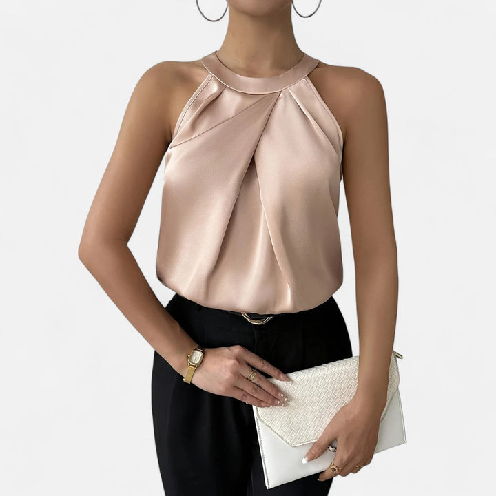 Female model wearing a pleated draped satin tank against a plain background.
