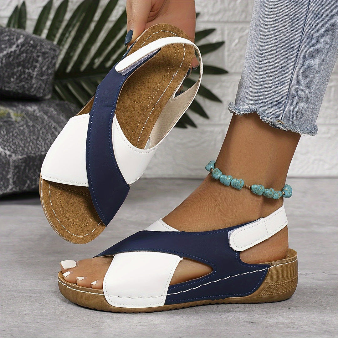 Woman showing outdoor-style sandals against a plain background