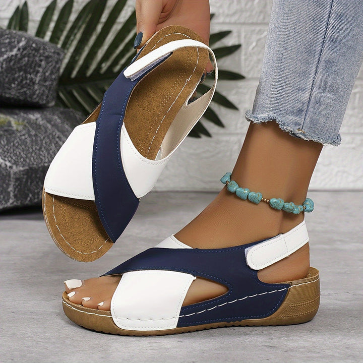 Woman showing outdoor-style sandals against a plain background