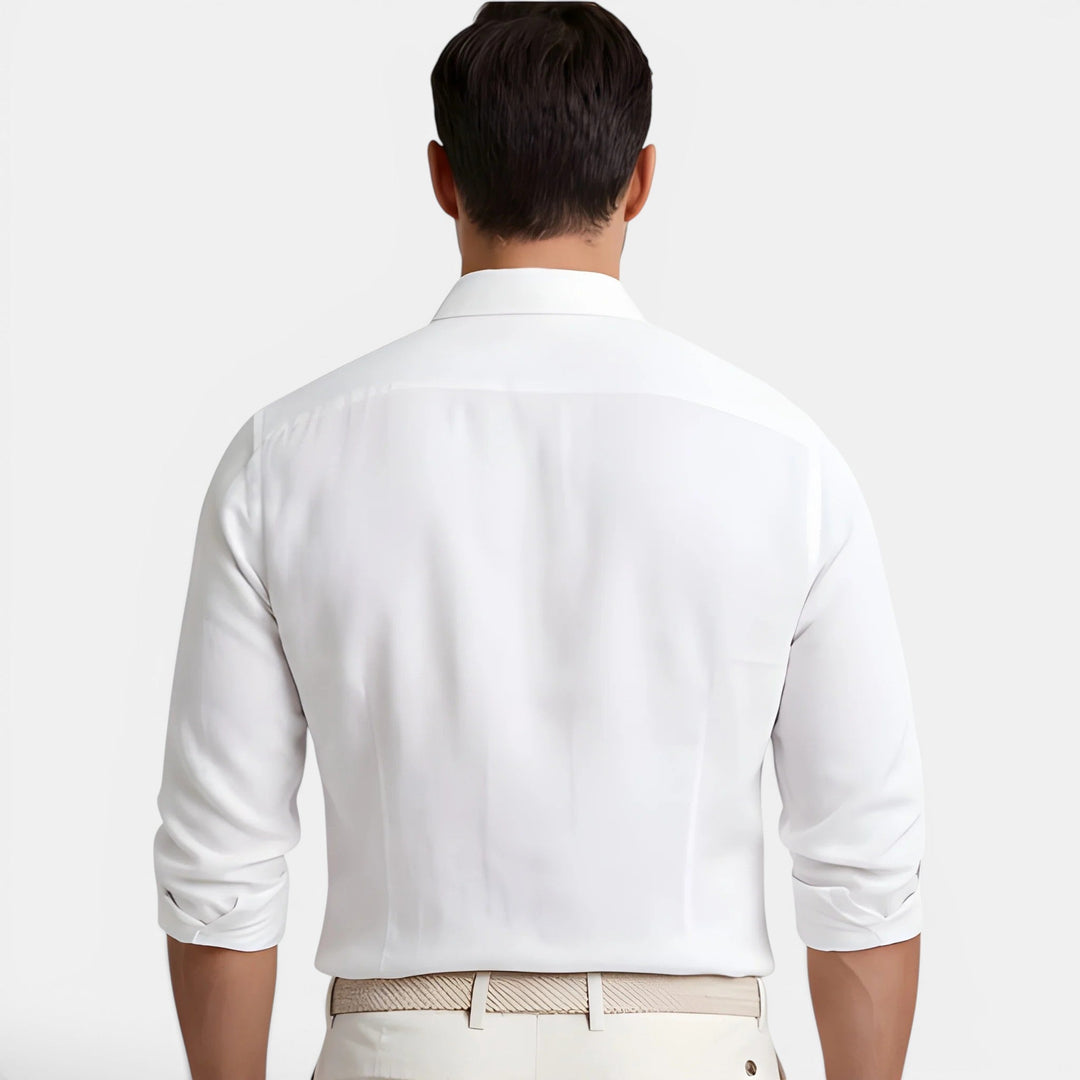  Man showcasing a tailored long sleeve shirt on a plain background.