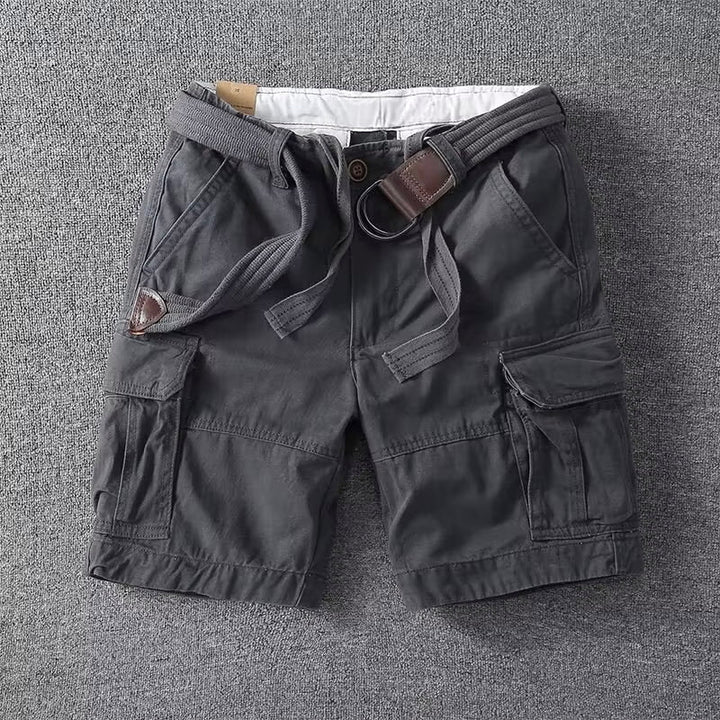  Man wearing utility cargo pants against a simple plain backdrop.