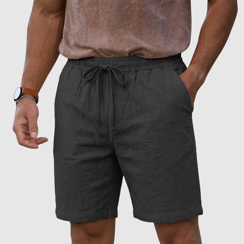  Model wearing relaxed men’s shorts with an adjustable waistband on a plain background.
