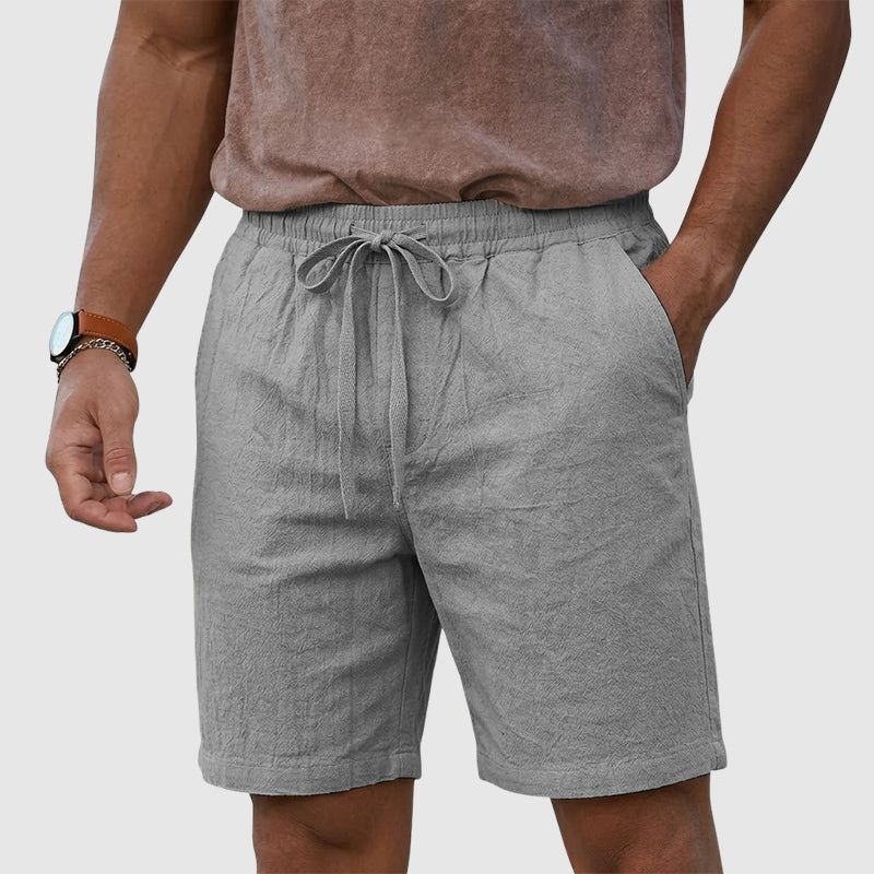  Male model wearing relaxed fit shorts with side storage on a plain background.