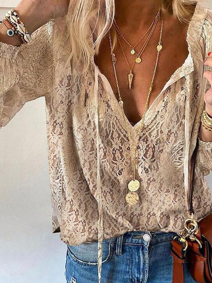 Woman wearing an elegant boho V-neck blouse against a plain background.
