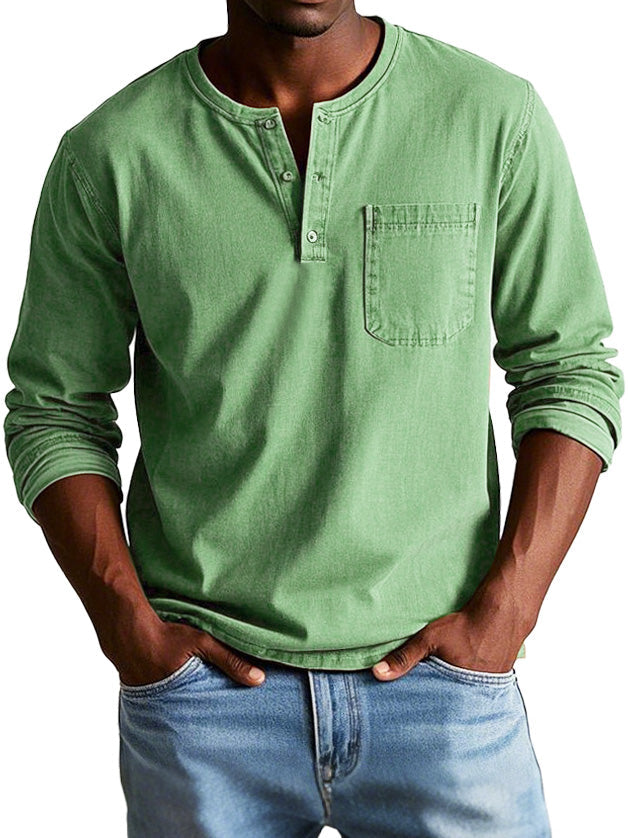 Man in a relaxed long sleeve Henley top with button neckline on a plain background.