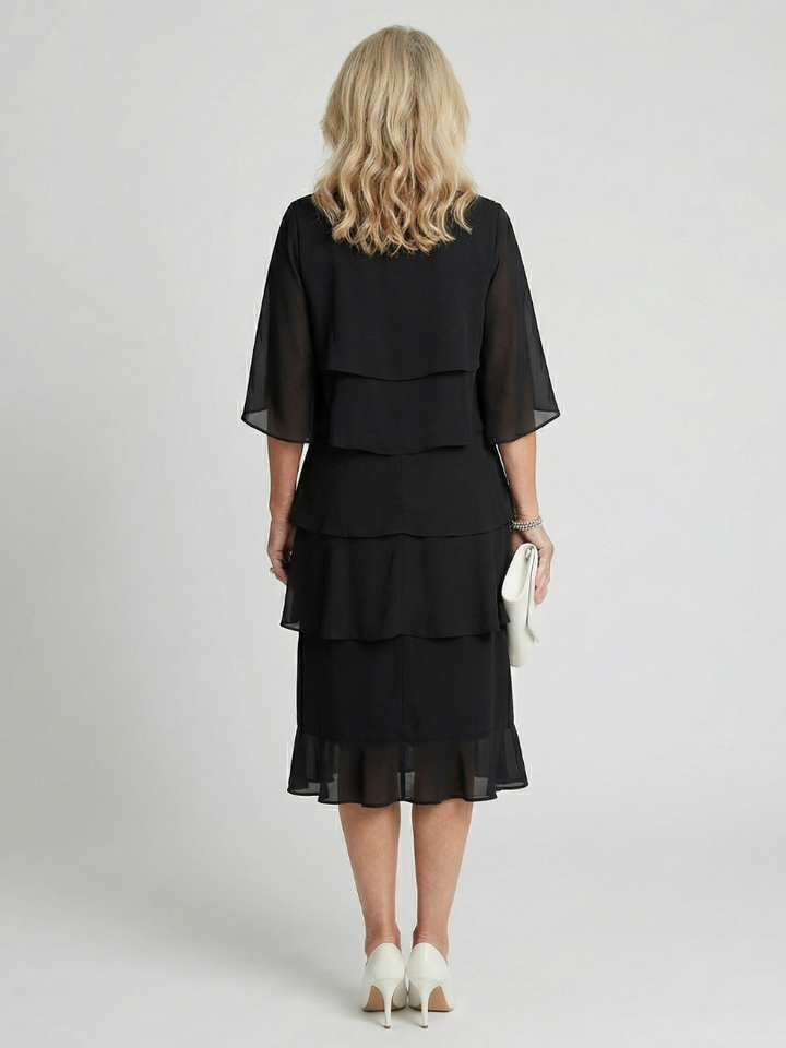 Female in a flutter sleeve midi dress styled with a soft flowing silhouette.