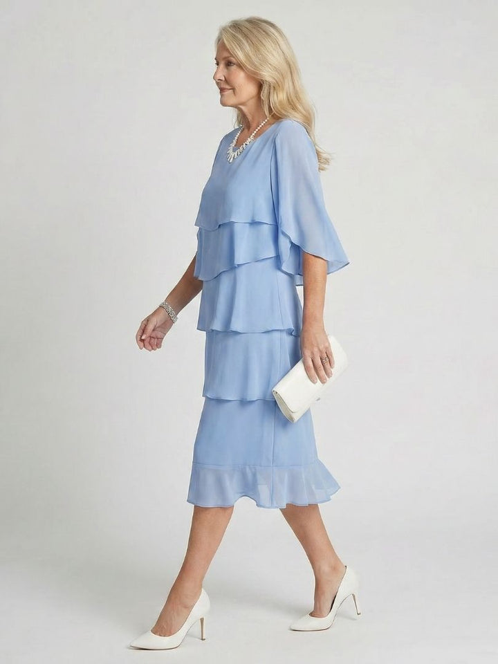 Female wearing a round neckline midi dress with flutter sleeves.
