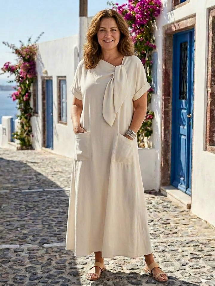 Female model wearing a formal dress against a outdoor background.