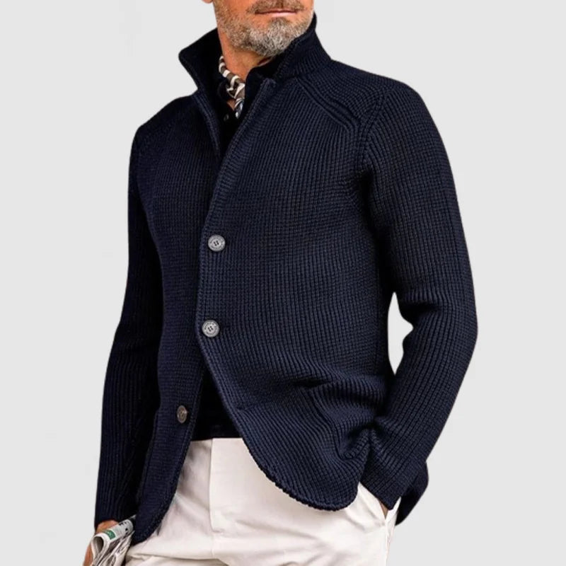  Man showcasing a relaxed blazer and straight-leg trouser set on a plain background.