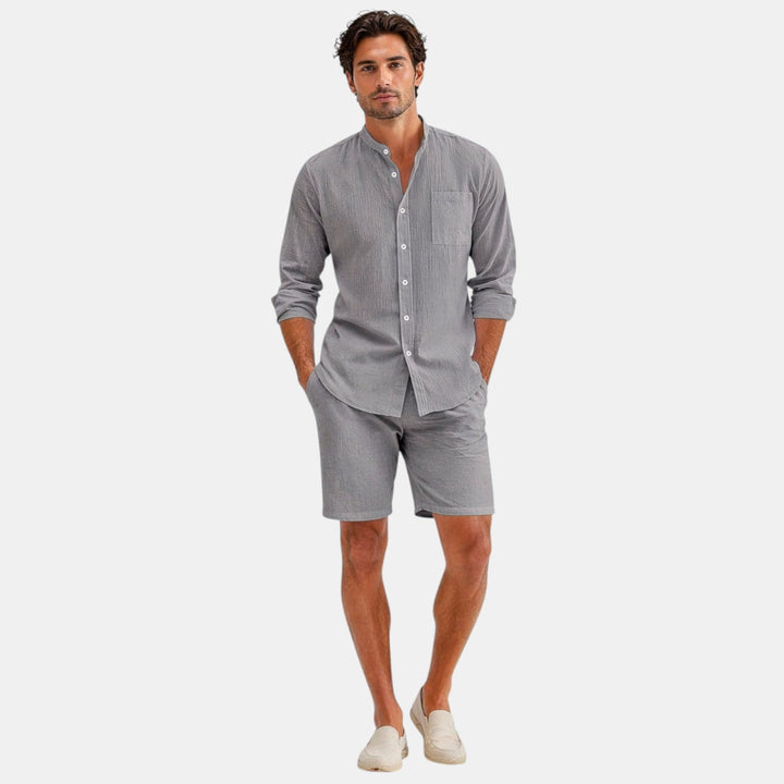 Male model wearing a relaxed short sleeve shirt and matching pants on a plain background.