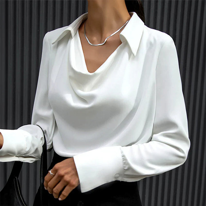 Woman presenting a sophisticated satin blouse on a clean background.