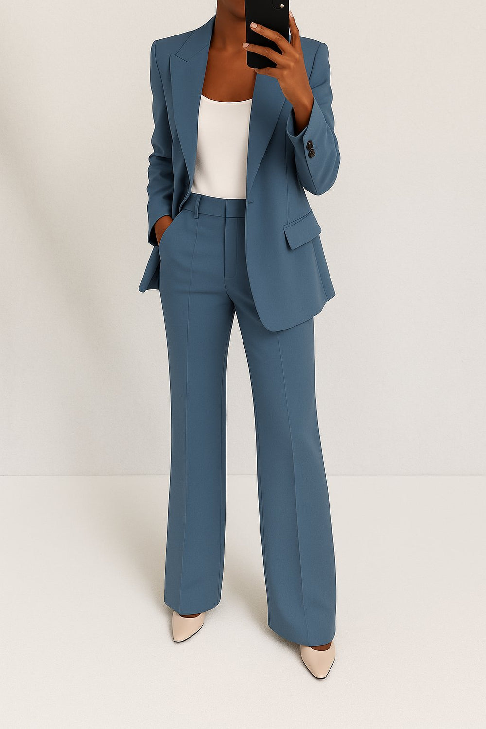Female model in a relaxed blazer and trouser set against a plain background.