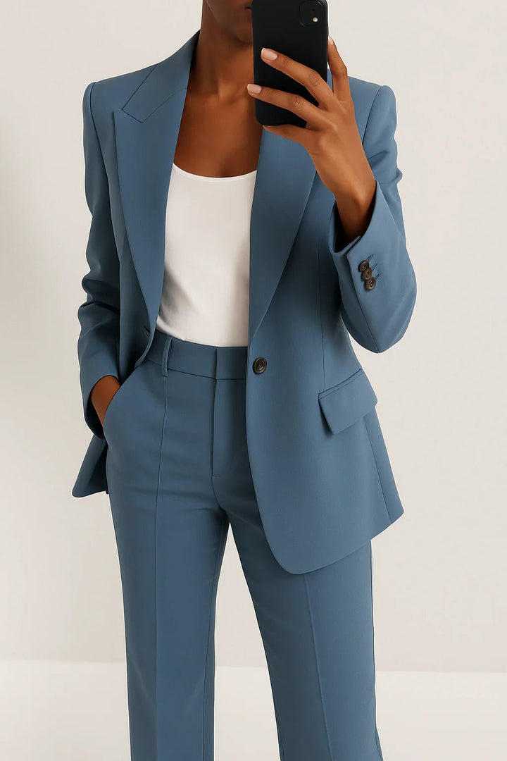 Woman wearing an oversized blazer set with trousers on a plain background.