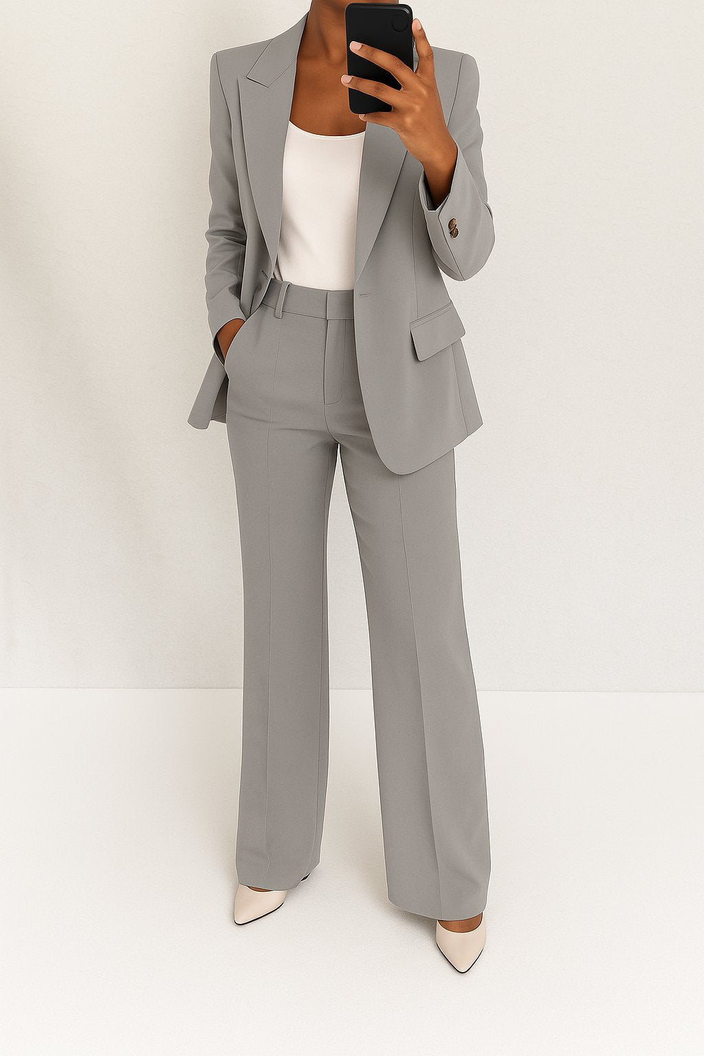 Model wearing a loose blazer set with straight trousers on a plain background.