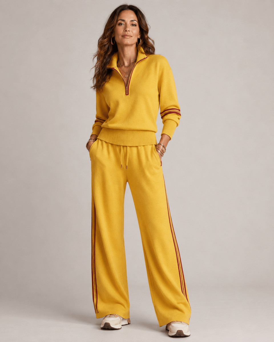  Female showcasing a stylish two-piece outfit with contrast stripe accents on a plain background.