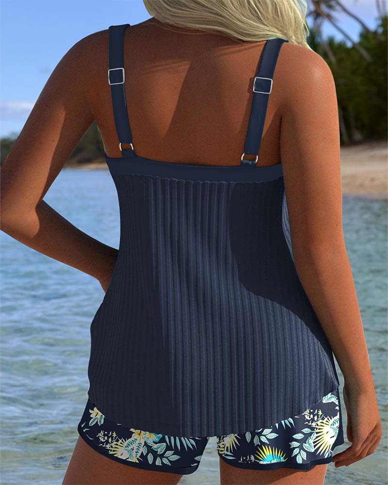 Woman in a striped two-piece tankini swimwear set with shorts on a clean background, back view