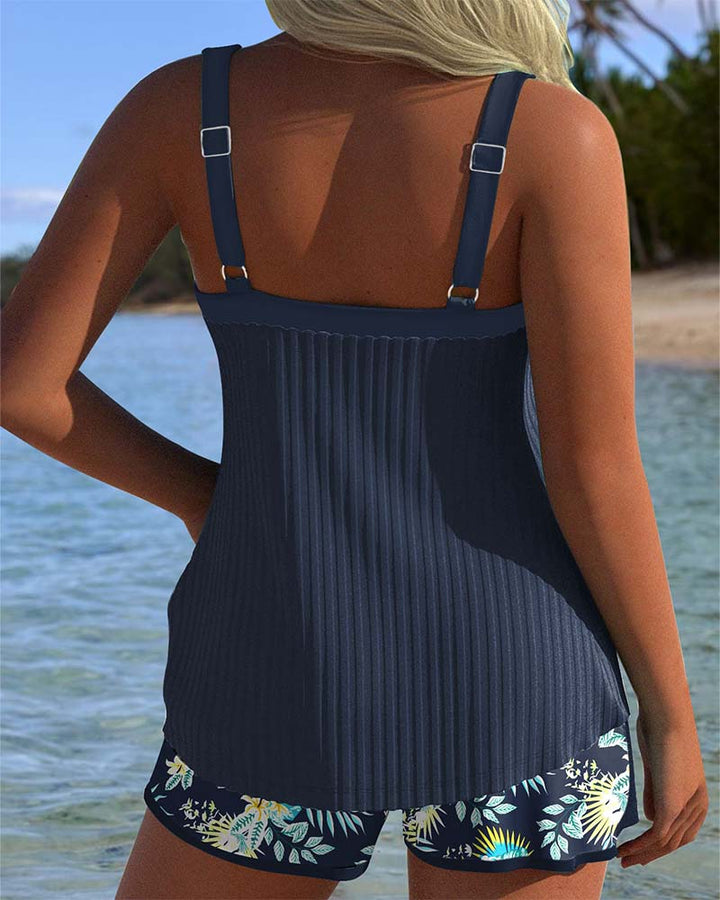 Woman in a striped two-piece tankini swimwear set with shorts on a clean background, back view