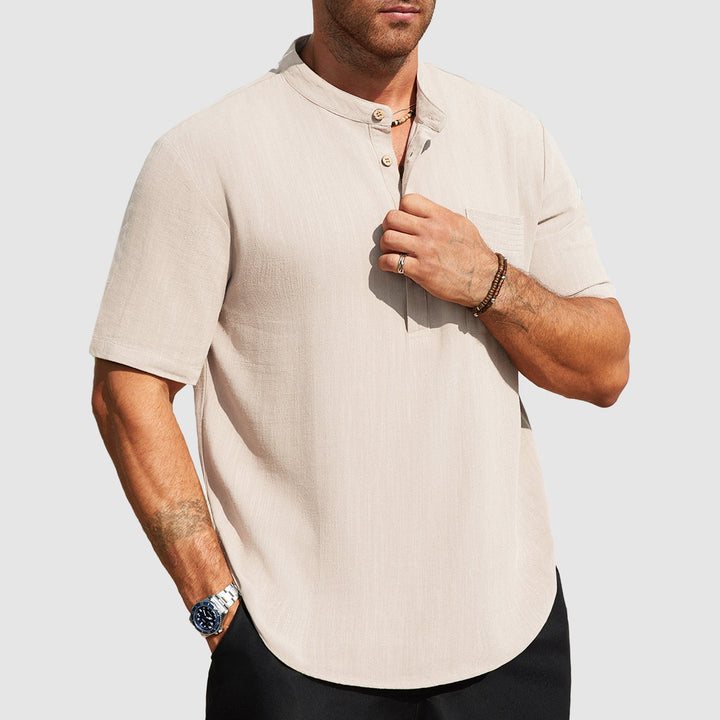 Male model wearing a relaxed open collar shirt against a plain background.