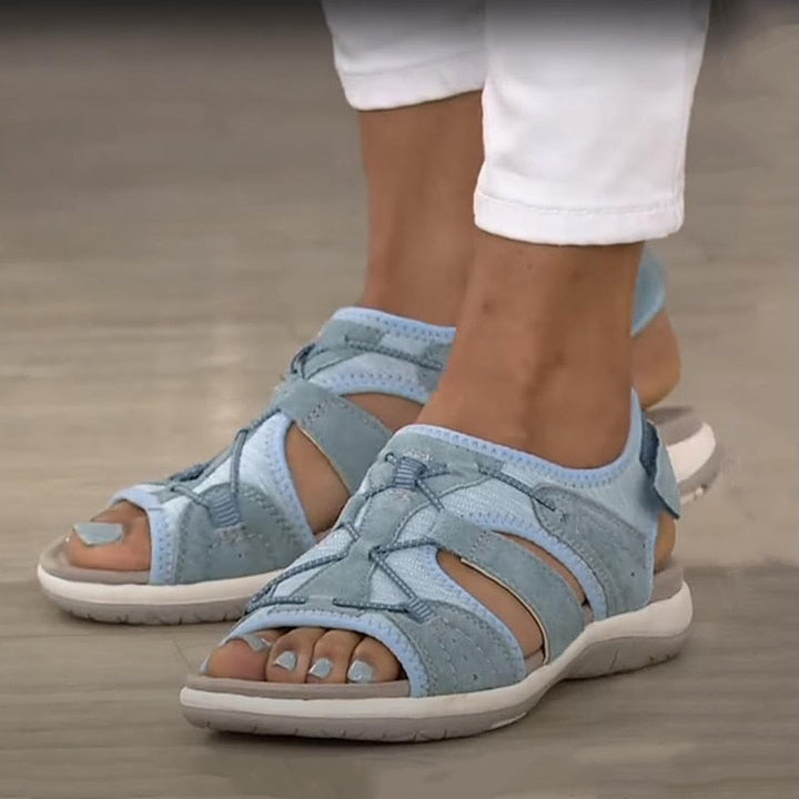 Slight angle sandals on feet plain background showing cushioning sole
