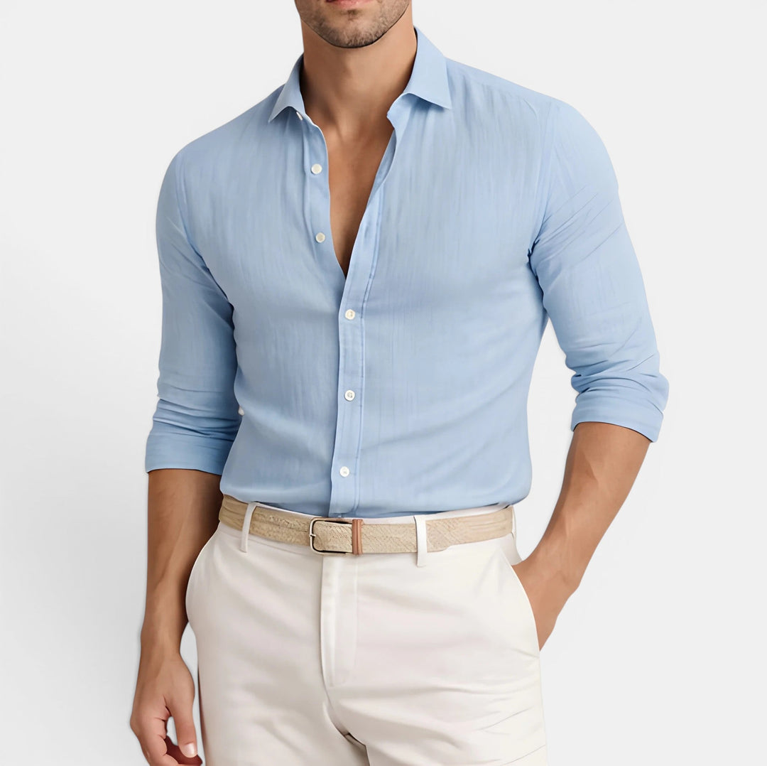  Man wearing a classic collared shirt with a clean look on a plain background.