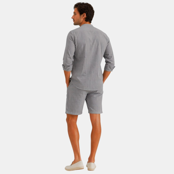  Male model wearing a breathable looking shirt and pants set against a plain background.