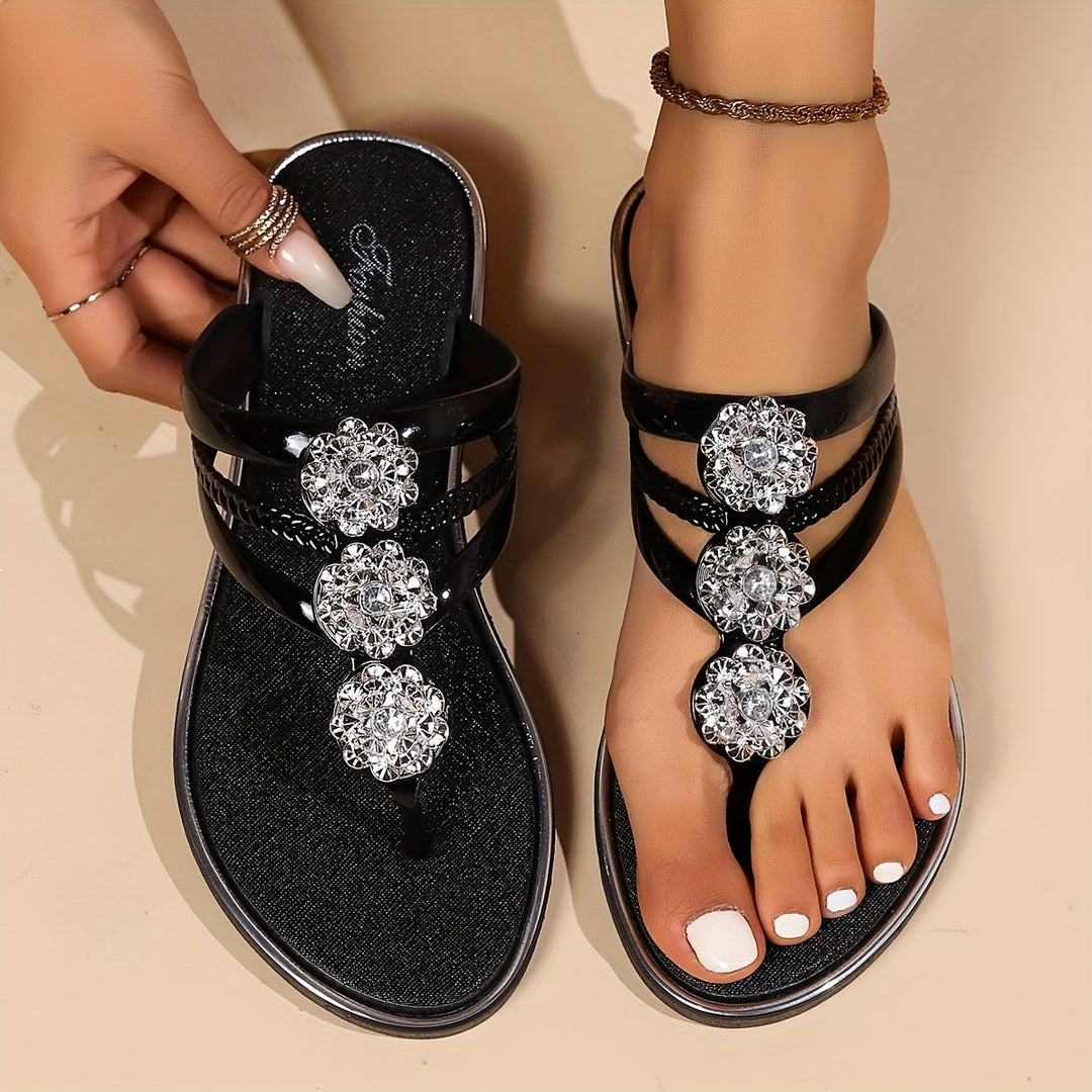  Woman showcasing rhinestone strap sandals against a plain background.
