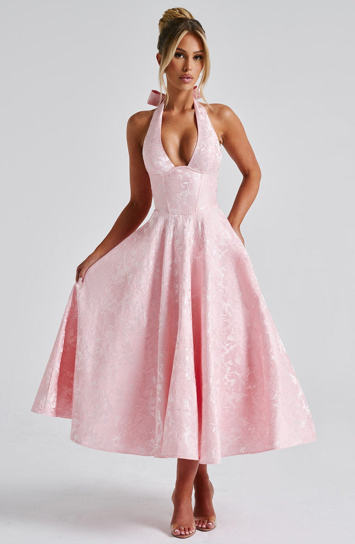 Female model wearing a halter neck midi dress against a plain background.