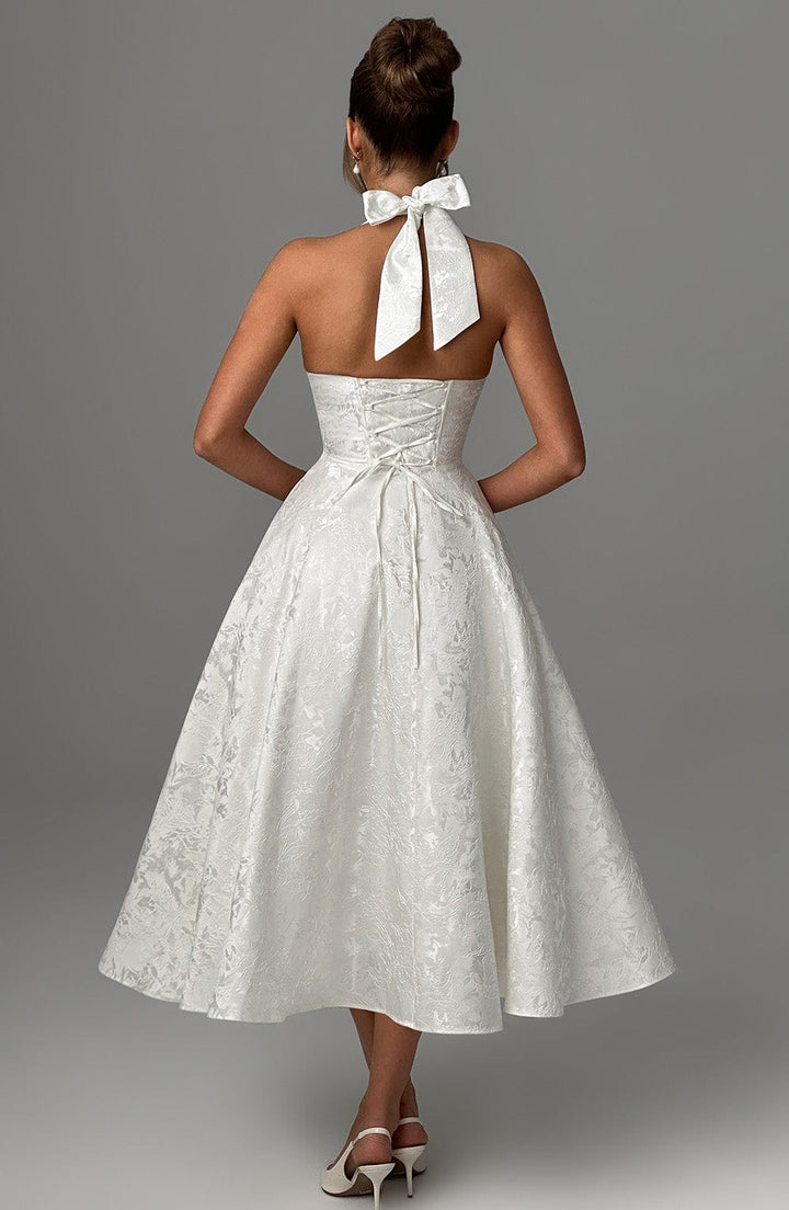 Woman in flattering fitted bodice dress, back studio view.