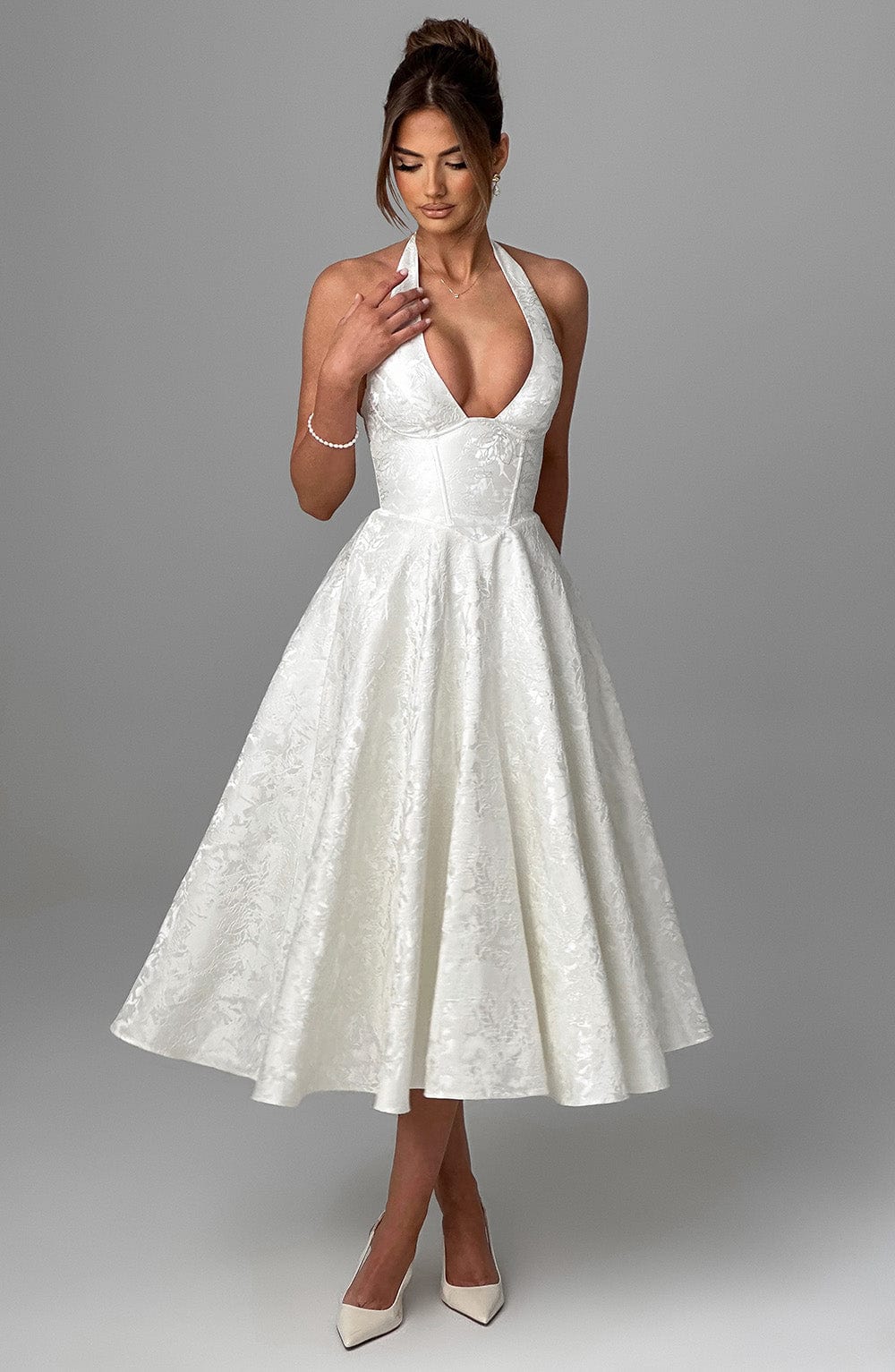 Woman wearing a halter neckline midi dress suitable for formal occasions and celebrations.
