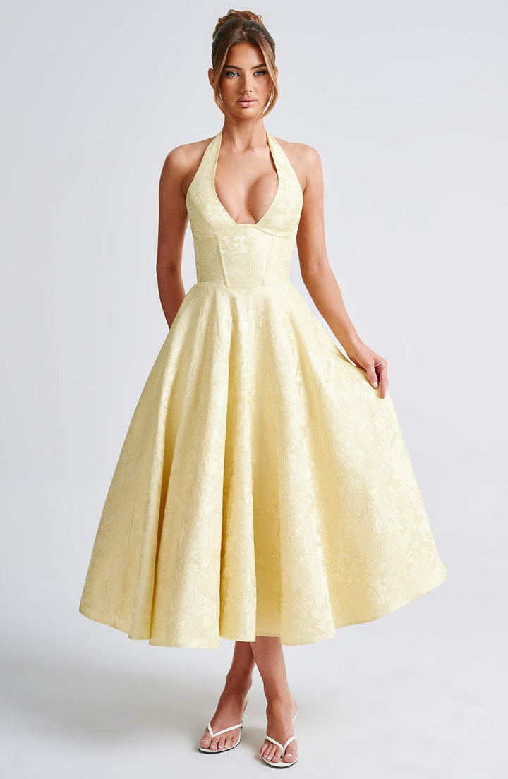 Female model showing dress silhouette on plain gray backdrop.