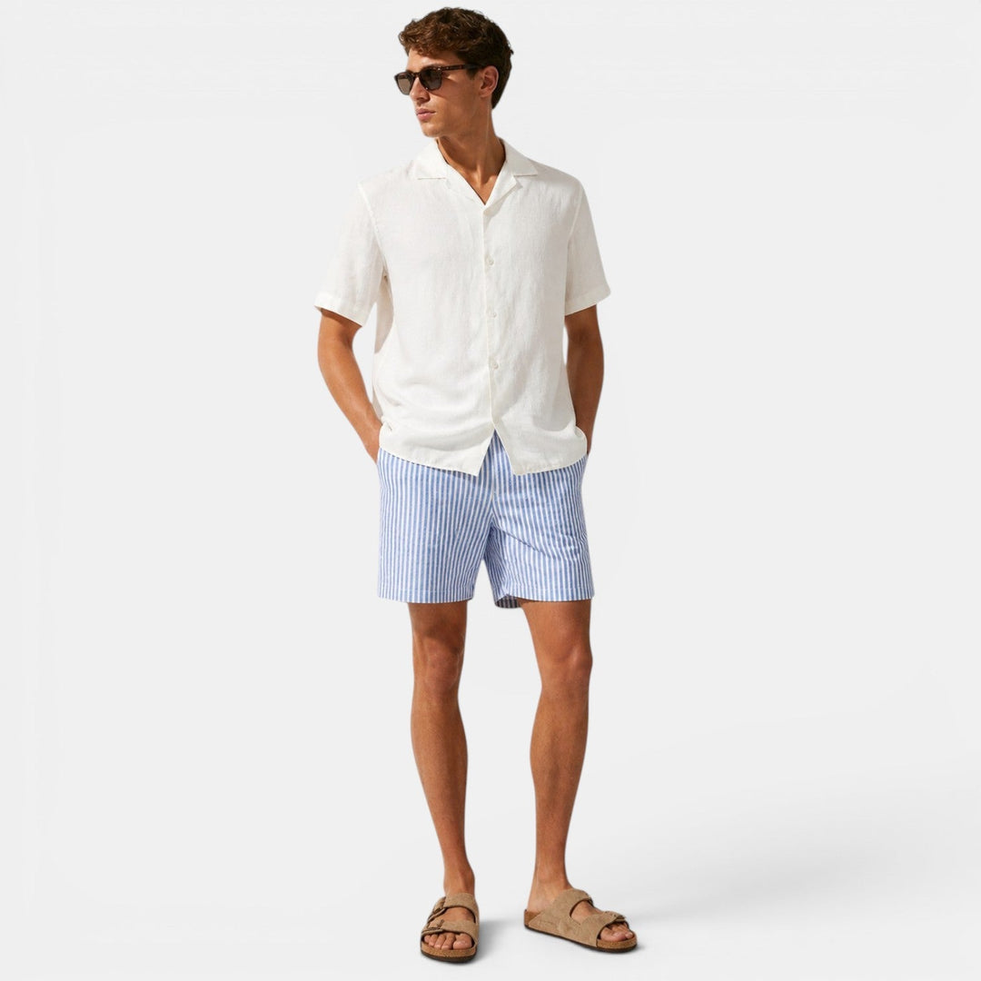 Man wearing relaxed-fit striped shorts displayed on a plain background.