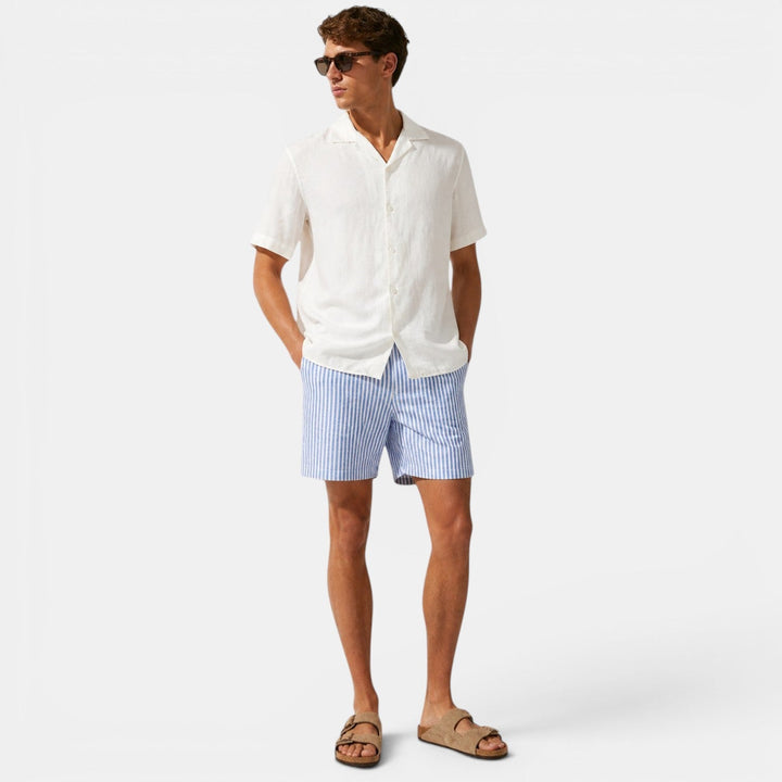 Man wearing relaxed-fit striped shorts displayed on a plain background.