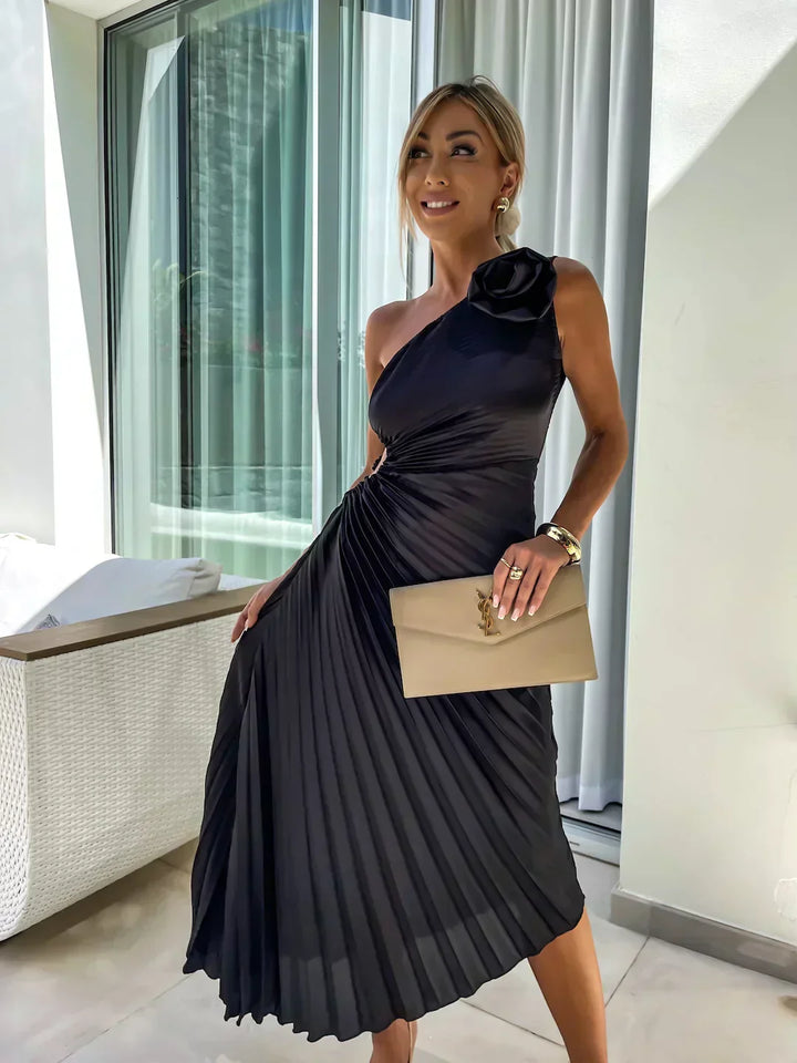 Woman model wearing an elegant asymmetrical midi dress with rose detail and soft structured silhouette on a clean background.