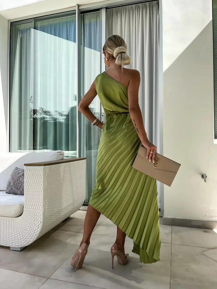 Model wearing a structured A-line midi dress with asymmetrical neckline and floral shoulder detail on a clean background, view angle