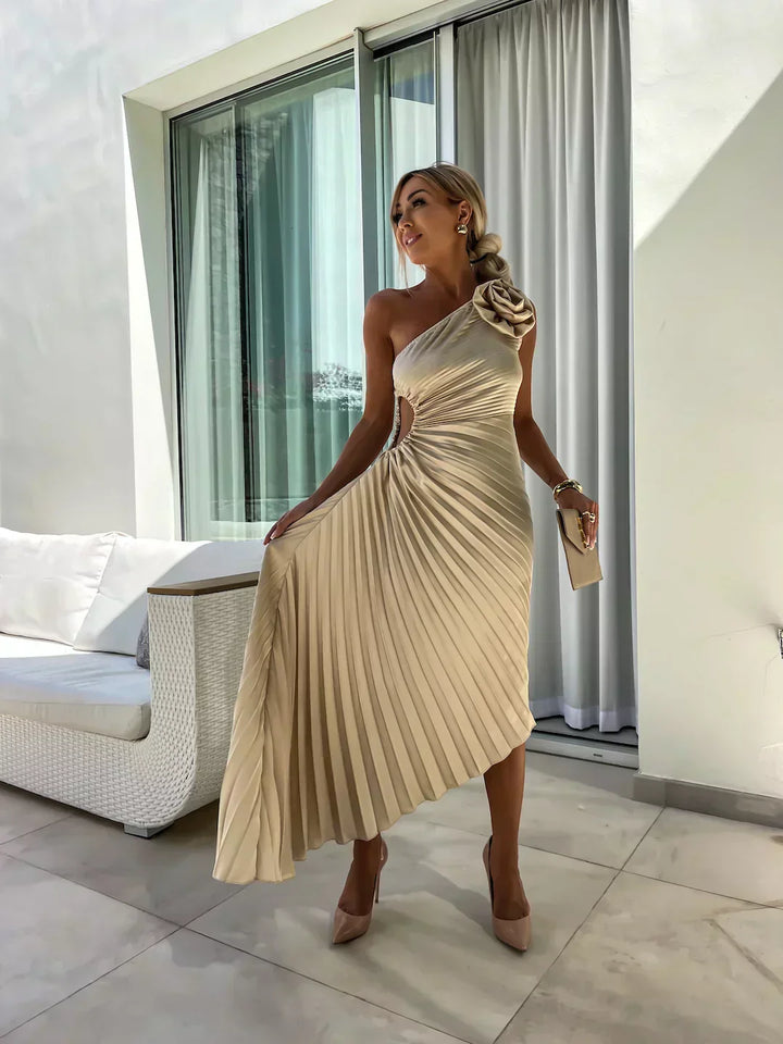 Woman model wearing a one shoulder A-line midi dress with balanced pleated skirt on a plain background.