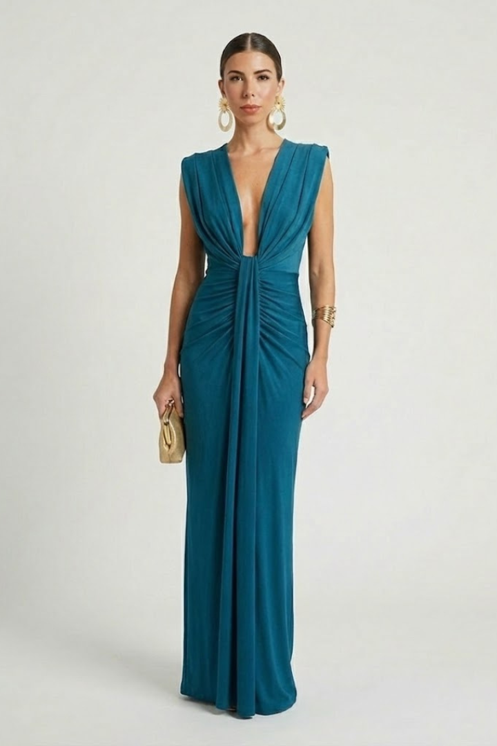 Woman wearing pleated sleeveless maxi dress on plain gray background.