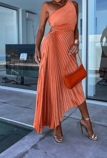 Female model wearing flowing maxi dress beside cream wall decor