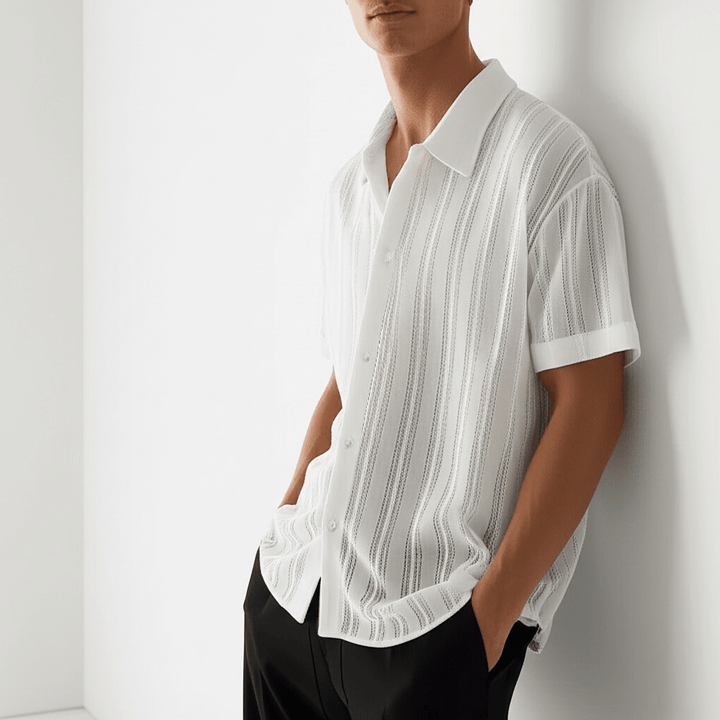  Man displaying a textured shirt with a relaxed fit on a plain background.
