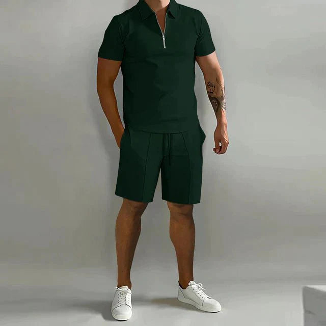 Male model showcasing a leisure outfit with a zip-up polo shirt on a plain background.