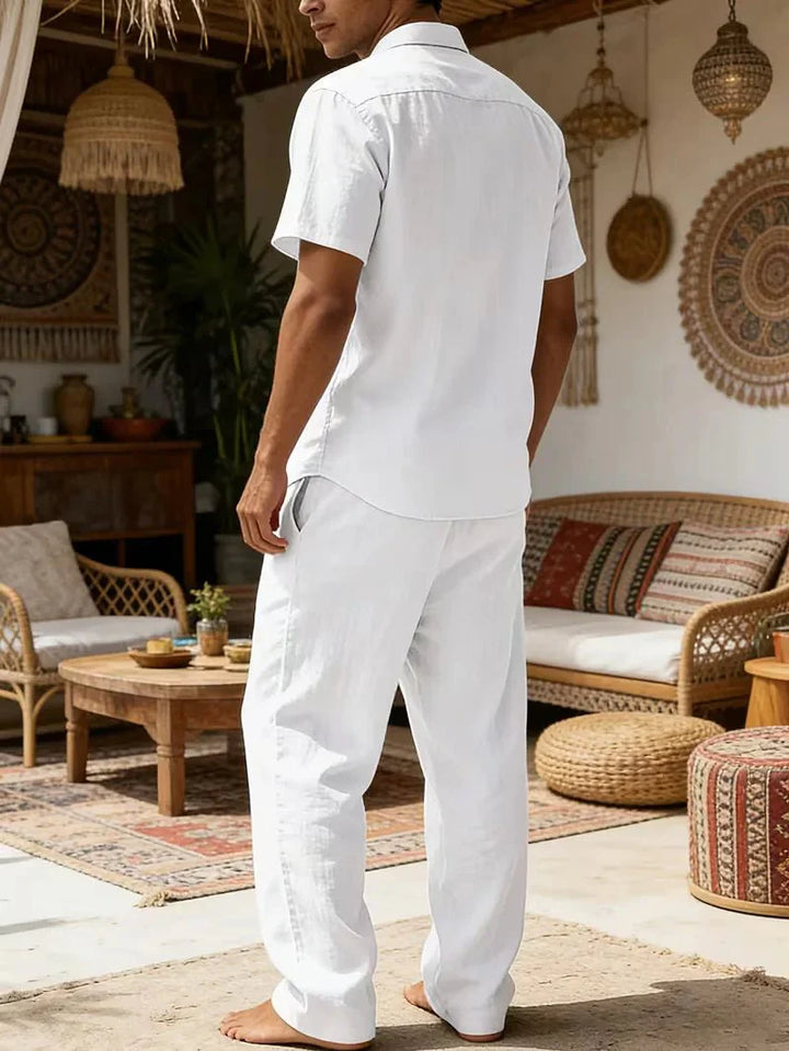  Male model displaying a short-sleeve shirt and matching trousers on a plain background.