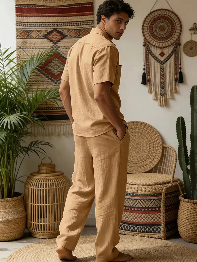 Man displaying a simple two-piece outfit for sunny days on a plain background.