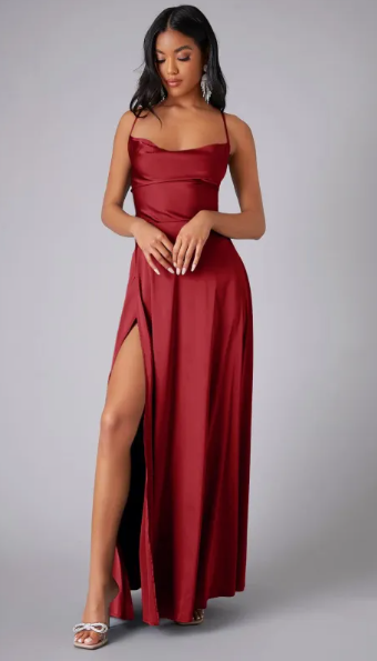 Female model wearing a long satin dress with soft draped neckline on a plain background.