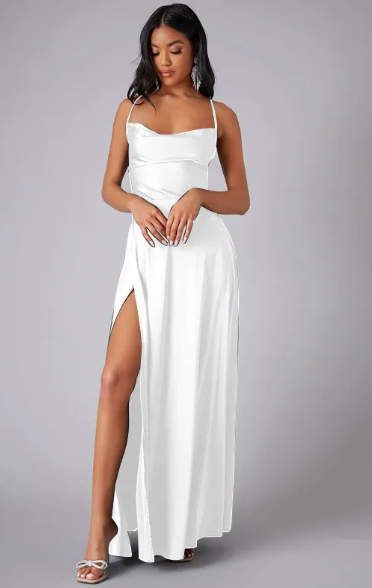 Woman posing in a glossy satin maxi dress with flowing skirt on a plain background.