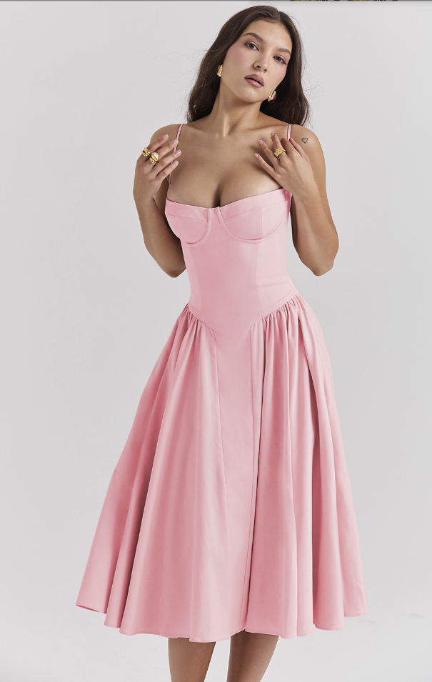 Female model posing in a graceful summer dress on a plain background