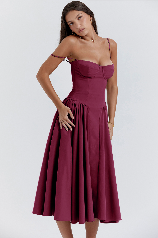 Woman posing in a breezy midi dress on a plain background