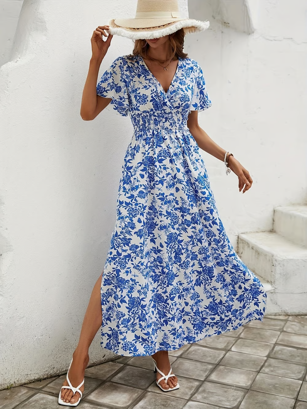 model wearing smocked waist floral dress with flutter sleeve detail