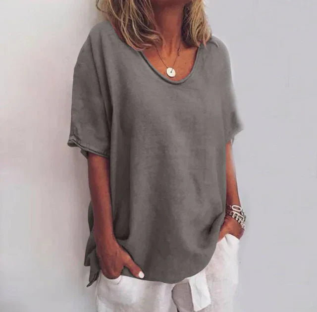 Female model showing flowing blouse fit on plain background front.